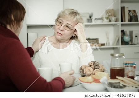 Mature lady comforting upset female Mature lady comforting upset female 42617875