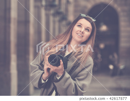 Young woman looking curious and taking pictures Young woman looking curious and taking pictures 42617877