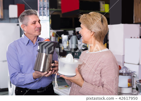 Wife and husband are buying in shop of household appliances juic Wife and husband are buying in shop of household appliances juic 42617950
