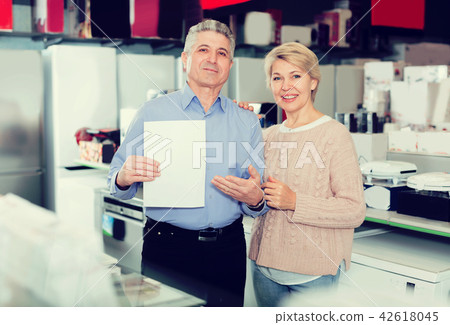 Man and woman 51-56 years old are buying in store on credit Man and woman 51-56 years old are buying in store on credit 42618045
