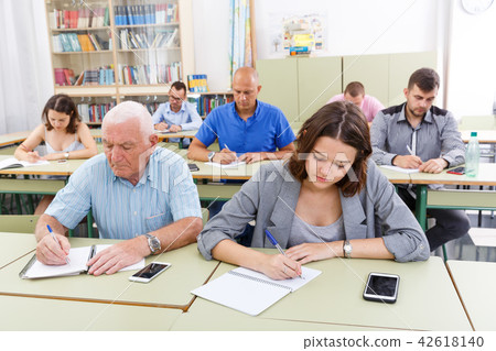 Young girl and mature man take a written exam 42618140