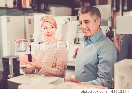 Husband and wife in shop of household appliances choose juicer 42618324