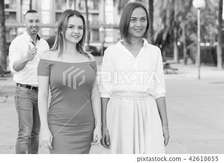 Young women are walking and stranger man is want acquaintance with them 42618655