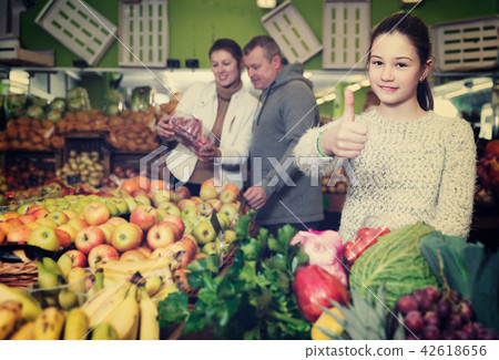 Girl with parents in greengrocery 42618656