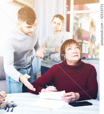 Dissatisfied man pointing to paper to offended mother 42618731
