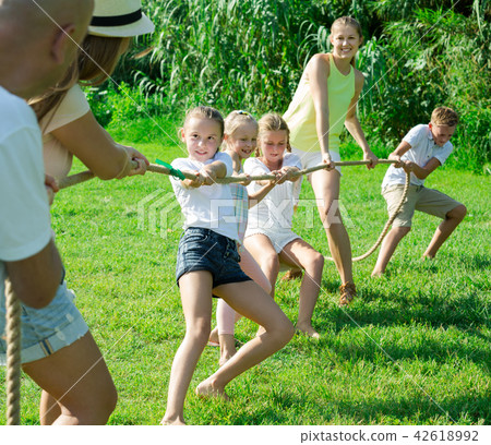 Kids with moms and dads playing tug of war 42618992