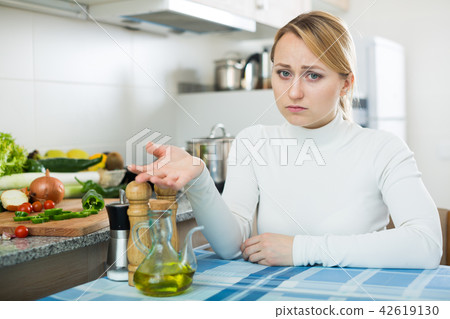 Portrait of tired woman at kitchen table Portrait of tired woman at kitchen table 42619130