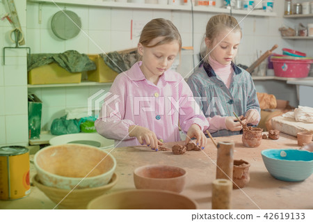 Smiling schoolgirls learning to make ceramics during arts Smiling schoolgirls learning to make ceramics during arts 42619133