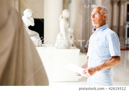 Man with guide at sculptures exposition Man with guide at sculptures exposition 42619312