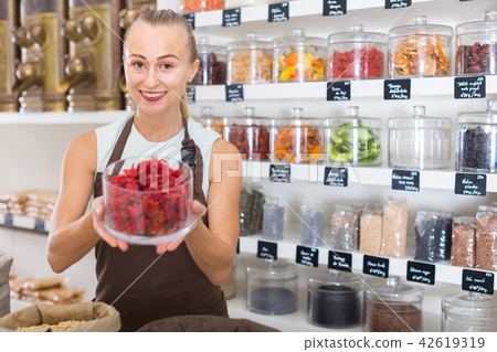 Young woman is offering dried flowers of Hibiscus in container Young woman is offering dried flowers of Hibiscus in container 42619319