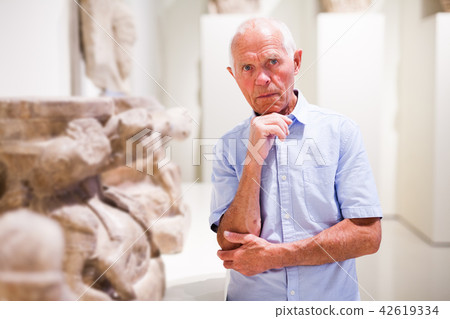 Mature man visiting sculptures exhibition 42619334
