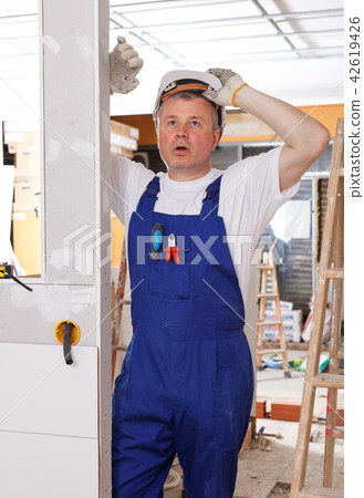 Perplexed worker inspecting room 42619426