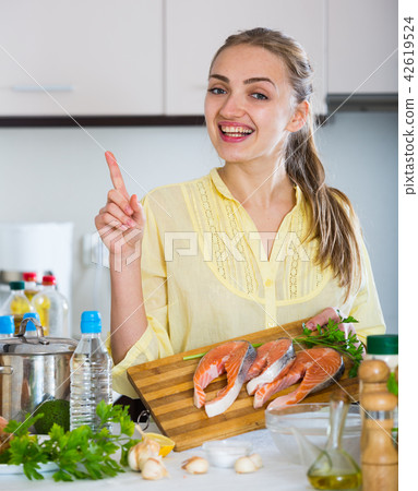 Girl in yellow blouse with fresh salmon fillet Girl in yellow blouse with fresh salmon fillet 42619524