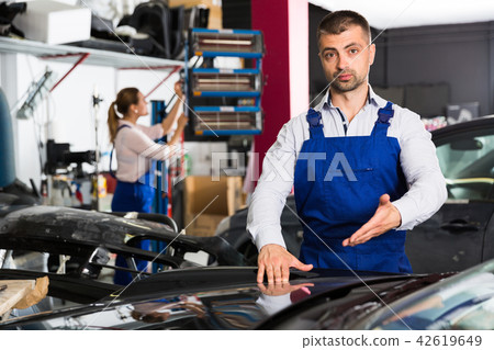 Male worker showing car after repainting 42619649