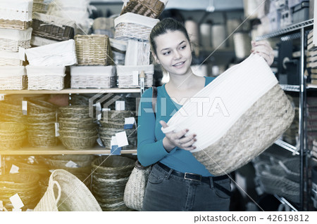 Pretty female buyer choosing wicker bag 42619812