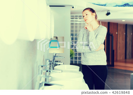 Positive woman customer choosing ceramic wash basin Positive woman customer choosing ceramic wash basin 42619848