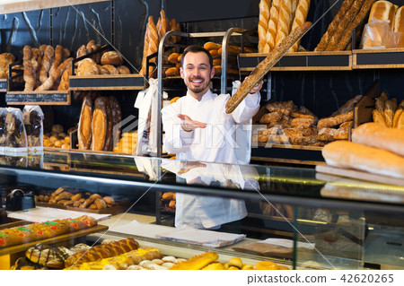 Seller offering fresh loaf of bread 42620265