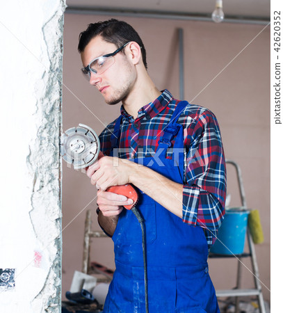 Worker using handheld circular saw 42620352