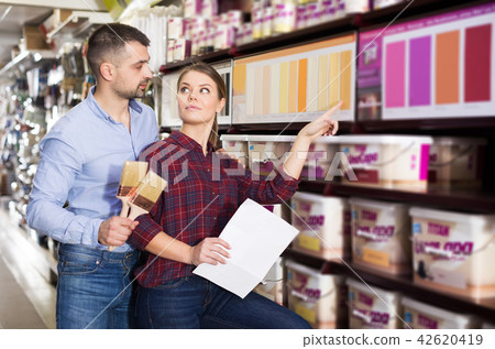 designer with shop list and brushes are looking color of paint 42620419
