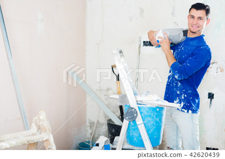 Man holding bag of putty Man holding bag of putty 42620439