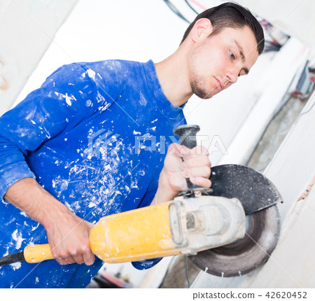 Male contractor using angle grinder 42620452