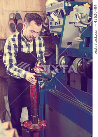 Male worker repairing shoe 42620494