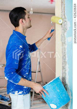 Male construction worker priming doorway Male construction worker priming doorway 42620684