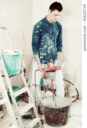 Worker mixing dry mortar 42620726