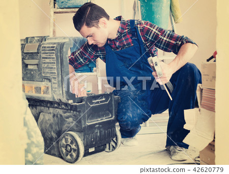 Worker looking for necessary tool in toolbox Worker looking for necessary tool in toolbox 42620779