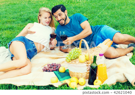 Smiling couple is lying with wineglasses and talking Smiling couple is lying with wineglasses and talking 42621040