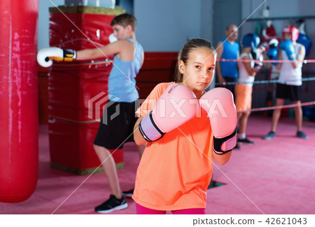 Girl in gloves posing during boxing training at gym Girl in gloves posing during boxing training at gym 42621043