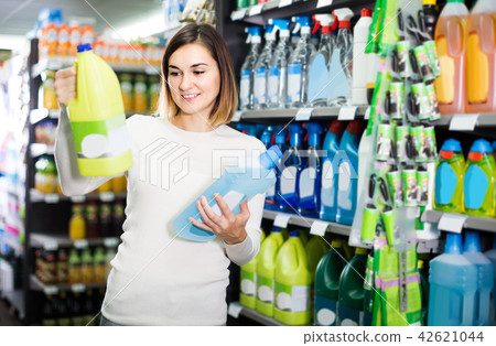 woman choosing best cleaners for home in supermarket woman choosing best cleaners for home in supermarket 42621044