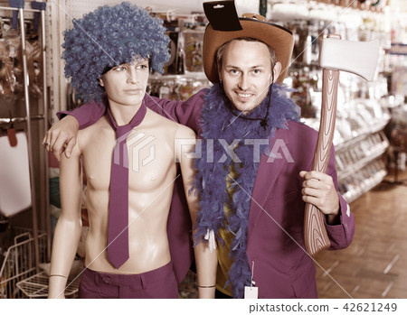 Man is staying with comically dressed dummy 42621249