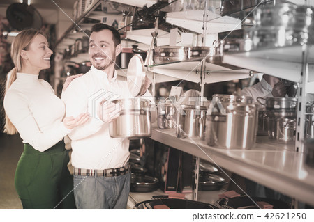 Ordinary loving couple deciding on best saucepan 42621250