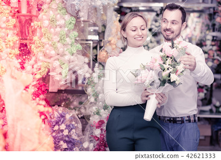 Couple choosing trendy flower decoration in store Couple choosing trendy flower decoration in store 42621333