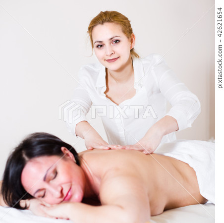 Female massage master is doing healty massage of back and loin to adult woman 42621654