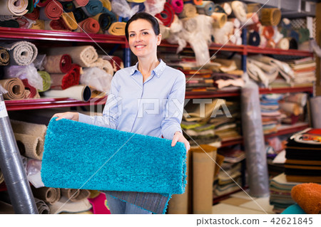Woman customer shopping carpet in interior stor 42621845