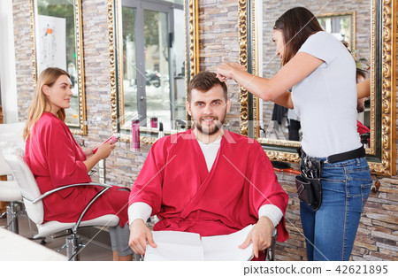 Female hairstylist working with male's hair in hairdressing salon 42621895