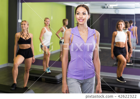 Portrait of fit woman performing step aerobics in fitness club Portrait of fit woman performing step aerobics in fitness club 42622322