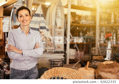 Adult woman buyer standing in shopping room with decor for home Adult woman buyer standing in shopping room with decor for home 42622335