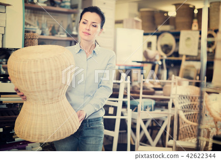 Positive female choosing new chair at store Positive female choosing new chair at store 42622344
