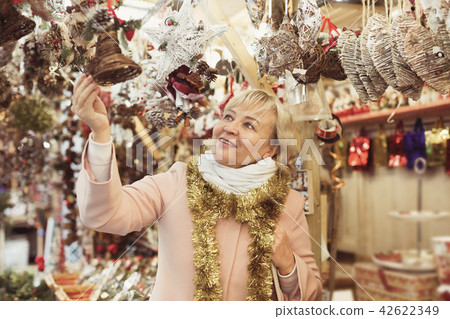 female in tinsel choosing decoration female in tinsel choosing decoration 42622349