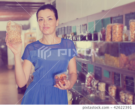 Woman taking nut beans in shop Woman taking nut beans in shop 42622391