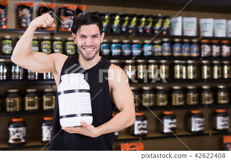 Young muscular man showing his biceps Young muscular man showing his biceps 42622408