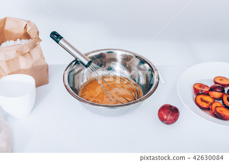 Metal bowl of whipped eggs with whisk Metal bowl of whipped eggs with whisk 42630084