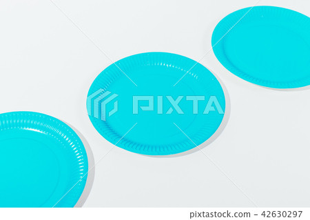 Three blue disposable plates of on white table 42630297