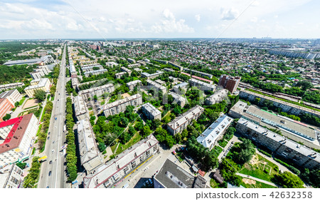 Aerial city view with crossroads and roads, houses, buildings, parks and parking lots. Sunny summer 42632358