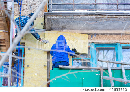 Workers warm and repair the facade of building. Workers warm and repair the facade of building. 42635710