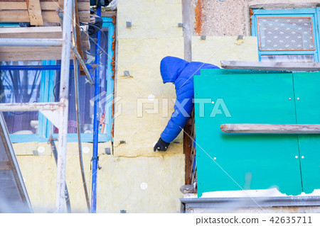 Workers warm and repair the facade of building. Workers warm and repair the facade of building. 42635711