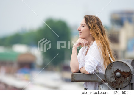 A young girl looks into the distance leaning  42636001
